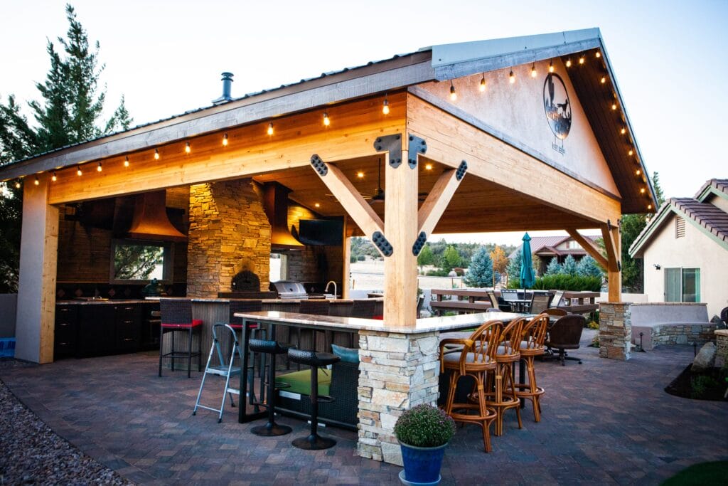 a pavillion with outdoor kitchen, bar, and seating, designed and installed by Zebrascapes