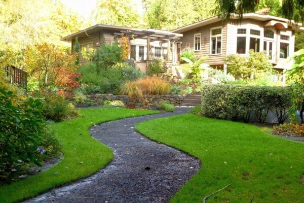 a lush front lawn with a paved path leading through it