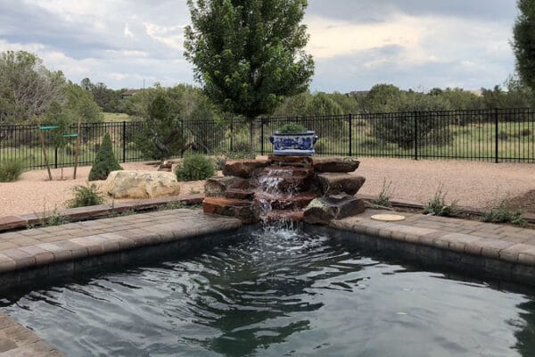 Closeup of an outdoor hot tub with water feature deisgned and installed by Zebrascapes