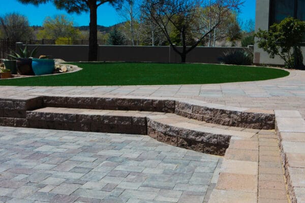 Hardscape stairs leading up to the patio area of an outdoor living space installed and designed by Zebrascapes