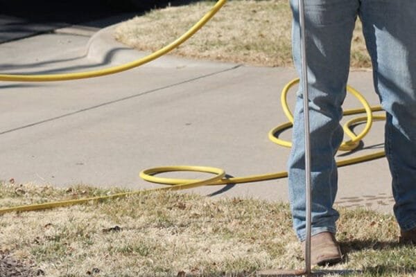 a professional landscaper applying tree fertilizer