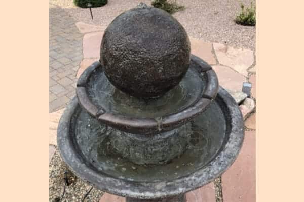 a two-tiered fountain with an orb on top: a water feature installed as part of an outdoor living upgrade by Zebrascapes