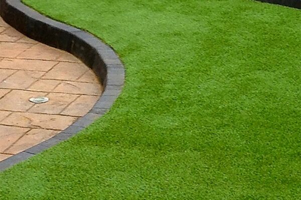 Turf installed by Zebrascapes with a two-tone hardscape path winding through it - Dewey-Humboldt